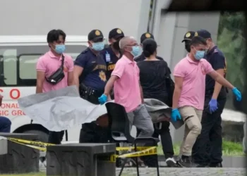 Security personnel outside a school in Tacloban City after a shooting incident in the Philippines.