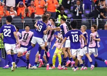 Japan celebrate their late equaliser against the Netherlands in a World Cup Group F match.