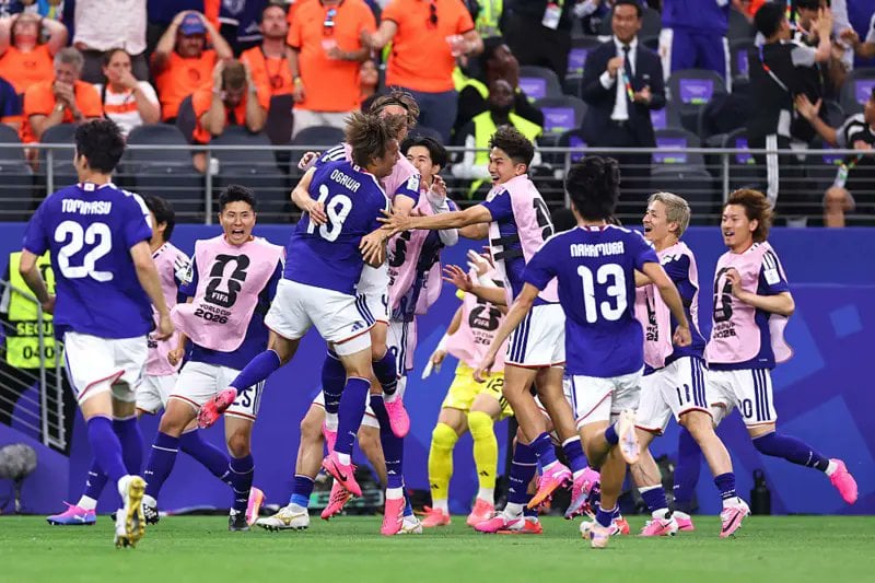 Japan celebrate their late equaliser against the Netherlands in a World Cup Group F match.