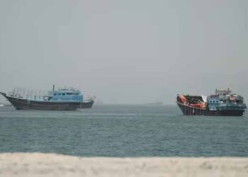 Cargo ships sailing through the Strait of Hormuz amid heightened regional security and naval monitoring
