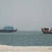 Cargo ships sailing through the Strait of Hormuz amid heightened regional security and naval monitoring