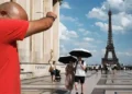People walking in Paris under intense sunlight during a severe Europe heatwave