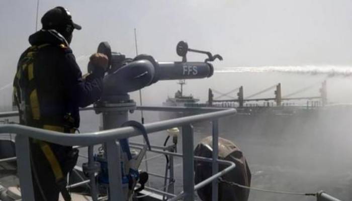 Naval firefighting operation controlling fire on merchant vessel MT Shalamar in the Arabian Sea near Gwadar.