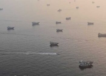 Large crude oil tankers sailing through the Strait of Hormuz carrying Middle Eastern energy exports.