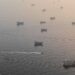Large crude oil tankers sailing through the Strait of Hormuz carrying Middle Eastern energy exports.