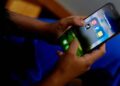 A smartphone displaying social media apps alongside Australia's online safety regulations.