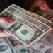 US dollar banknotes with financial market data reflecting stronger safe-haven demand amid Middle East tensions.