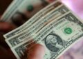 US dollar banknotes with financial market charts ahead of the Federal Reserve interest rate announcement.