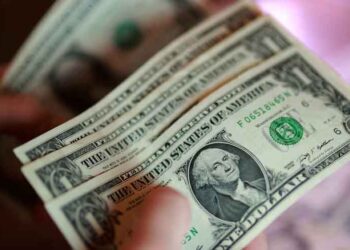 US dollar banknotes with financial market charts ahead of the Federal Reserve interest rate announcement.