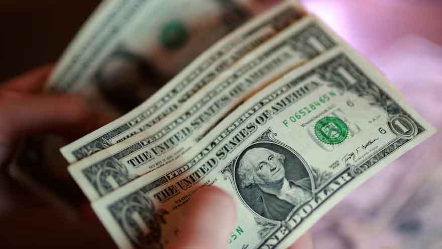 US dollar banknotes with financial market charts ahead of the Federal Reserve interest rate announcement.