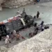 Emergency responders conduct rescue operations at the site of a deadly passenger coach crash in Balochistan's Dana Sar area.