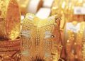 Gold bars and market price board showing rising gold prices in Pakistan