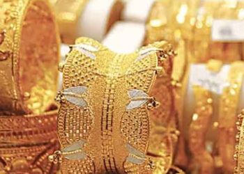 Gold bars and market price board showing rising gold prices in Pakistan