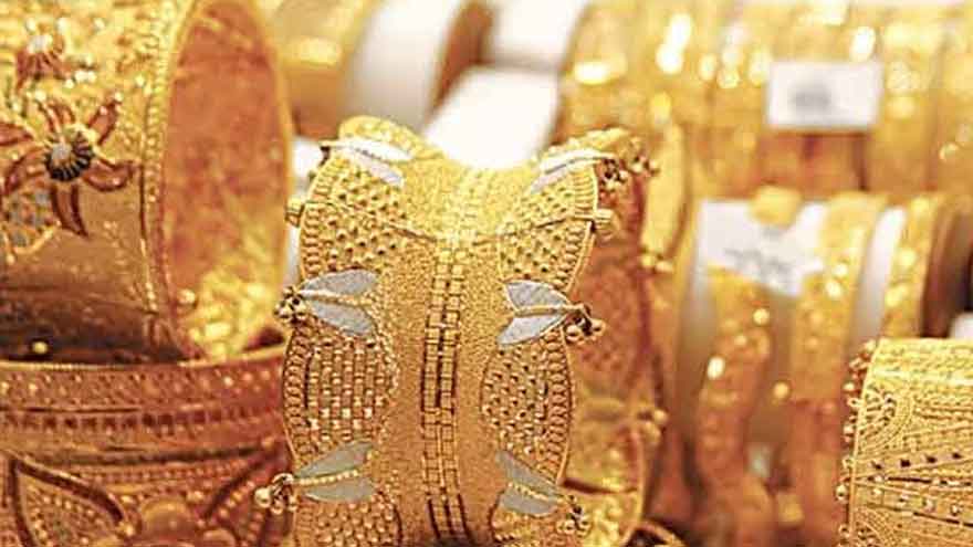 Gold bars and market price board showing rising gold prices in Pakistan