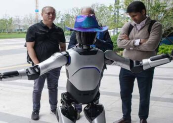 Foreign investors visiting a Chinese factory showcasing robotics and advanced manufacturing technology