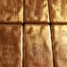 Gold bullion and market charts as investors monitor US inflation and Federal Reserve rate expectations.