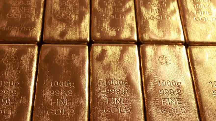 Gold bullion and market charts as investors monitor US inflation and Federal Reserve rate expectations.
