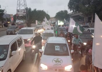 Citizens waving Pakistani flags during a Defence Day rally in Karachi