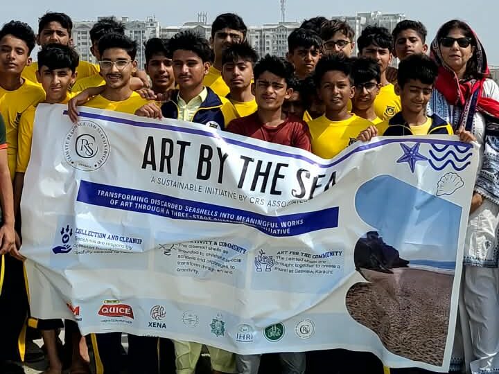 Students collecting litter and discarded seashells during a beach cleanup drive at Seaview, Karachi.