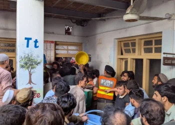 Rescue personnel search through debris after a private school roof collapses in Peshawar, injuring children and killing students and teachers.